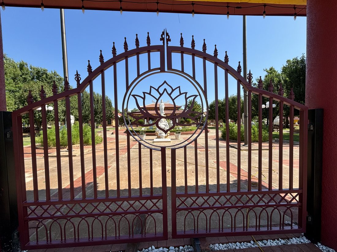 Large red temple gate with lotus design.